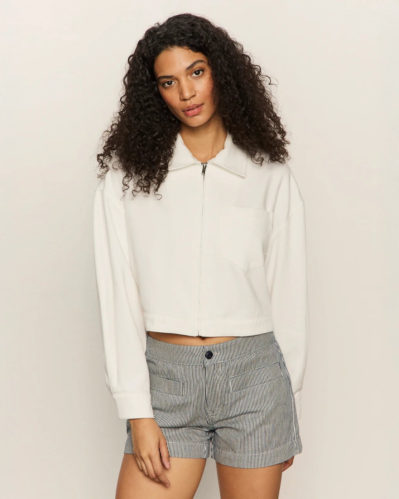 Woman wearing a white cropped zip jacket