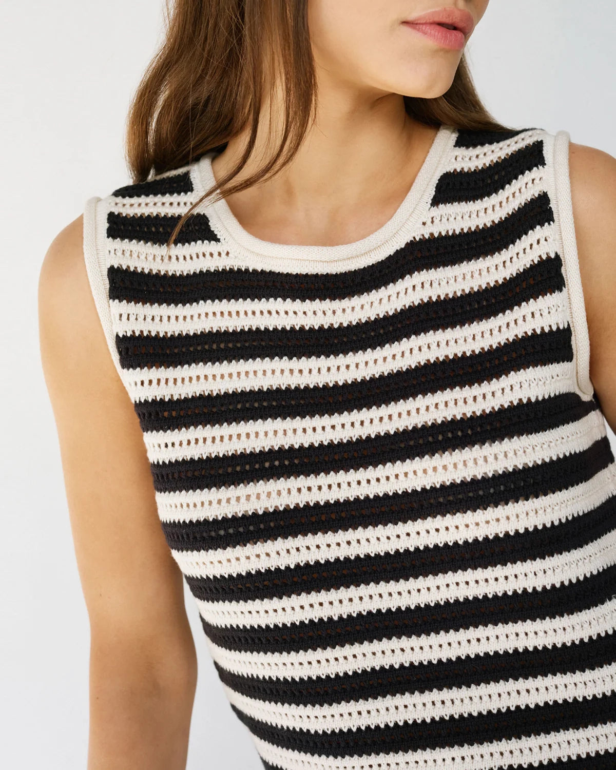 Woman wearing a crochet knit black and white striped sleeveless top 
