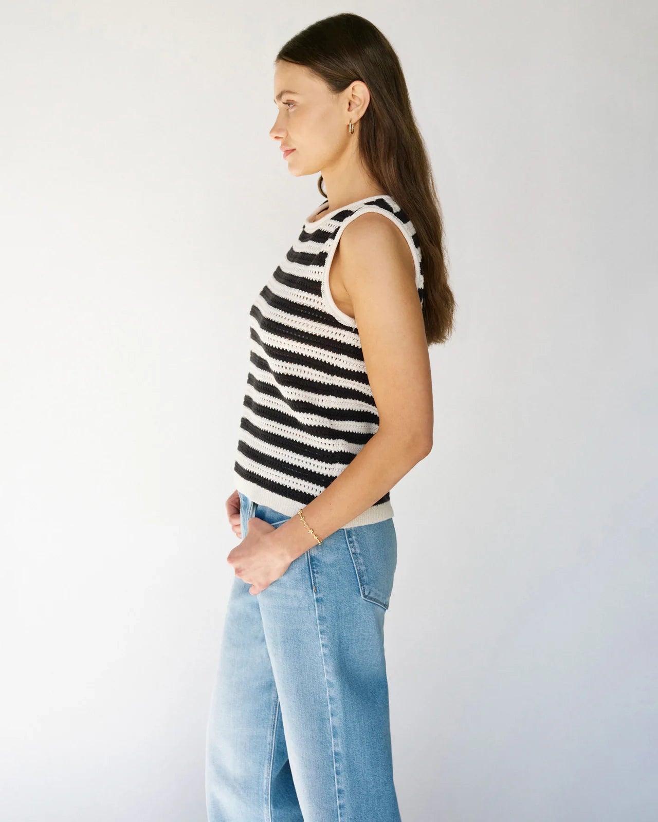 Woman wearing a crochet knit black and white striped sleeveless top 