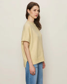 Woman wearing a light yellow oversized cashmere tee sweater