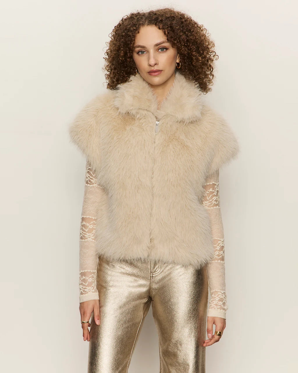 Woman wearing a faux fur short sleeve vest in blonde cream colour