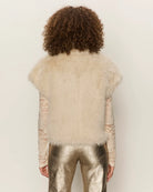 Woman wearing a faux fur short sleeve vest in blonde cream colour