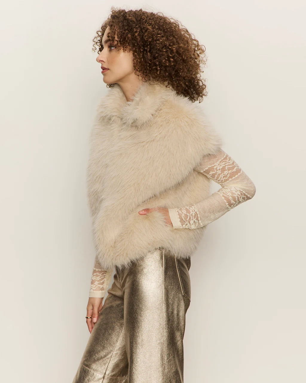 Woman wearing a faux fur short sleeve vest in blonde cream colour