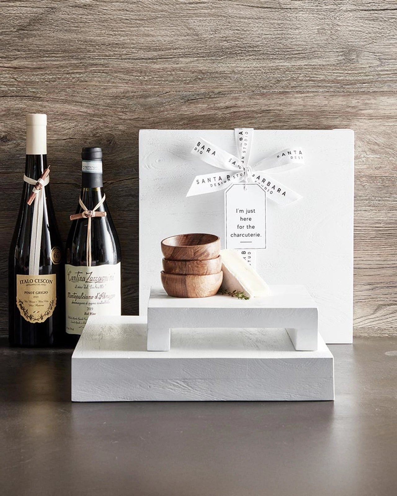 set of pinch bowls made out of wood sitting on table tray and shown with bottles of wine for entertaining