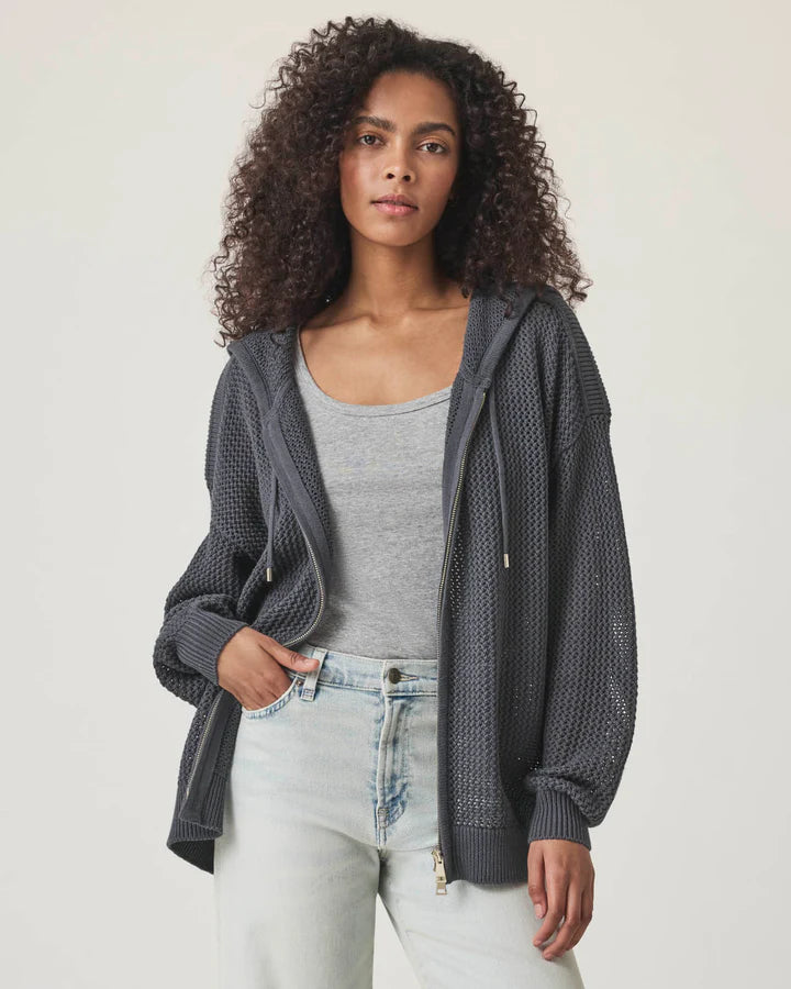 Woman wearing a netted gray zip up cardigan 