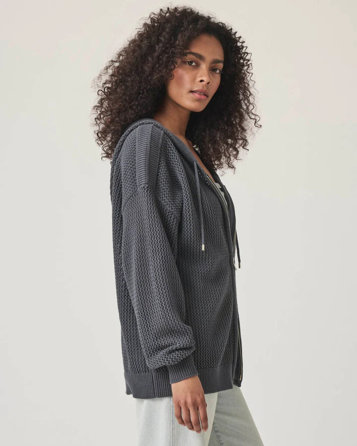 Woman wearing a netted gray zip up cardigan 