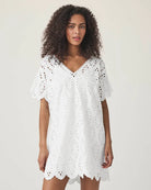 Woman wearing a white lace eyelet cotton dress 