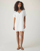 Woman wearing a white lace eyelet cotton dress 