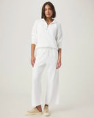 woman wearing white wide-leg terry cloth drawstring pants  and matching half zip sweater