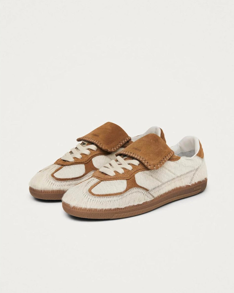 pair of pony hair cream and tan leather sneakers with a rubber sole