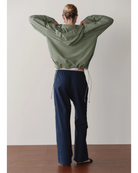 green rain jacket with wide sleeves and a hood
