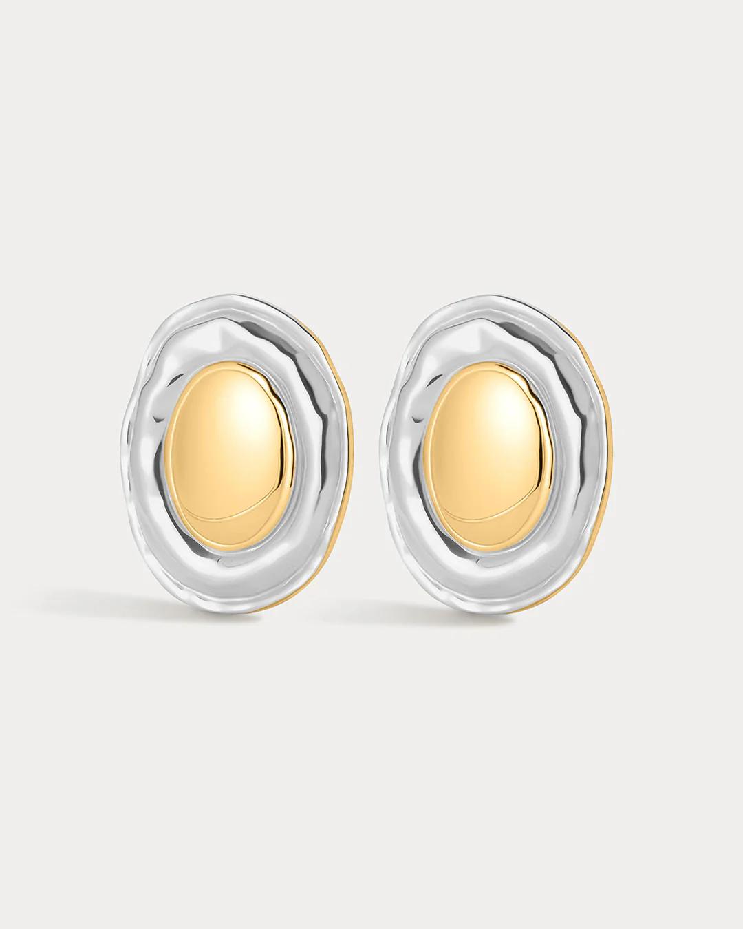 Pair of gold and silver earrings on a light gray background