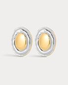 Pair of gold and silver earrings on a light gray background