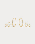 Set of gold hoop earrings on a light gray background