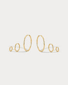 Set of gold hoop earrings on a light gray background