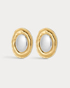 Gold and silver earrings on a light gray background
