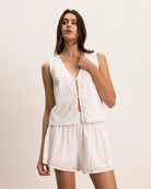 Woman wearing a white lace eyelet blouse with matching shorts