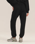woman wearing black cotton sweatpants with a matching sweatshirt