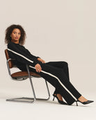 Woman wearing a black outfit with white stripes and matching trousers