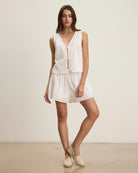 Woman wearing a white eyelet sleeveless top and shorts