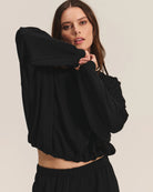 Woman wearing a black cotton sweatshirt with matching joggers