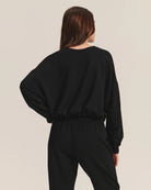 Woman wearing a black cotton sweatshirt with matching joggers