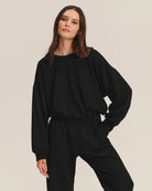 Woman wearing a black cotton sweatshirt with matching joggers