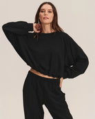 Woman wearing a black cotton sweatshirt with matching joggers