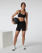 woman wearing black athletic shorts with weight training ball