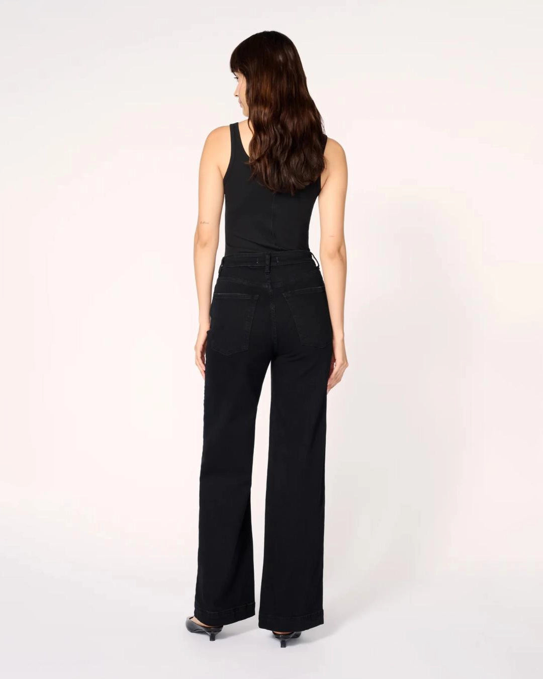 a woman wearing black wide-leg jeans with a thick cuff