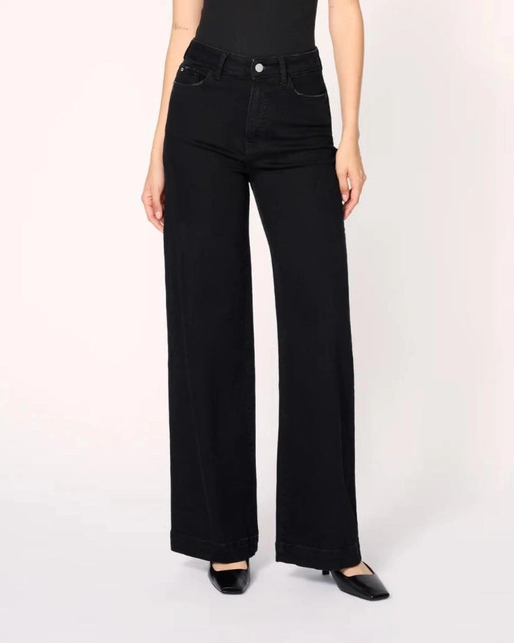 a woman wearing black wide-leg jeans with a thick cuff