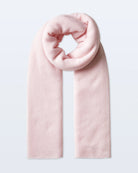a woman wears a large cashmere travel wrap scarf in soft pink