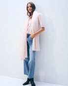 a woman wears a large cashmere travel wrap scarf in soft pink