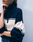 Woman wearing a navy and white striped cashmere sweater with quarter zip