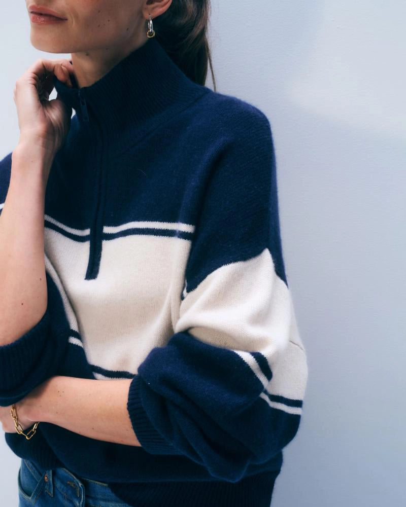 Woman wearing a navy and white striped cashmere sweater with quarter zip