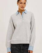 grey pullover sweatshirt with half buttons down and a blue striped collar