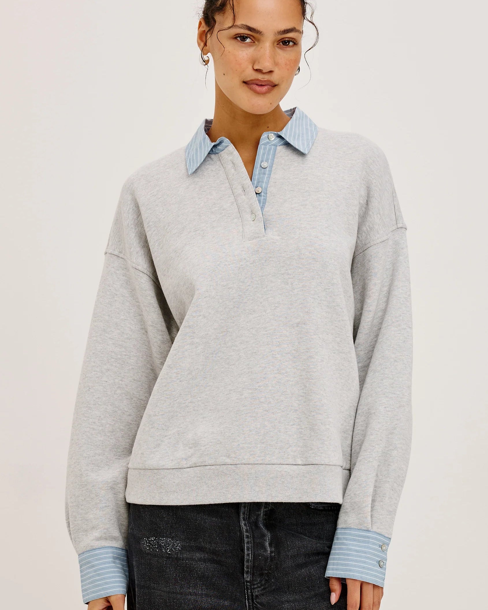 grey pullover sweatshirt with half buttons down and a blue striped collar