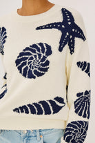 cream sweater with blue seashells all over