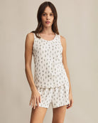 Woman wearing a white sleeveless top and shorts with a floral print