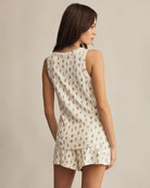 Woman wearing a white sleeveless top and shorts with a floral print