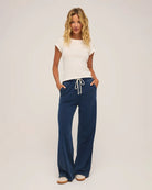 woman wears a blue drawstring denim pant  and white t-shirt by Z Supply