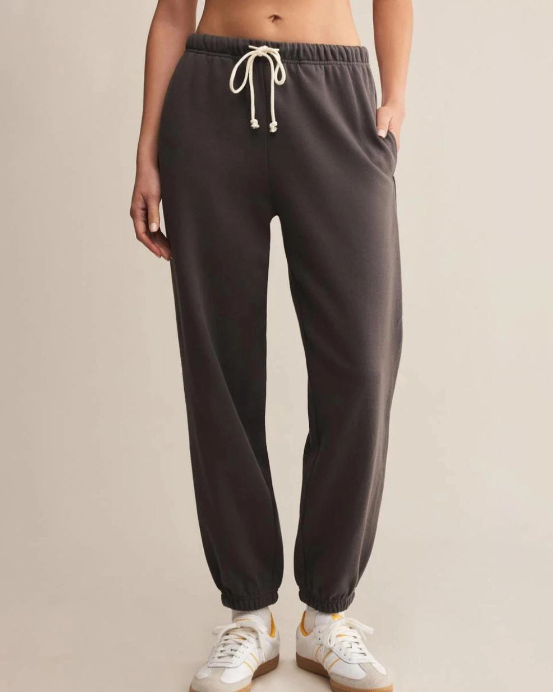 a woman wears dark gray cotton sweatpants with cream drawstring
