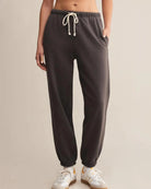 a woman wears dark gray cotton sweatpants with cream drawstring