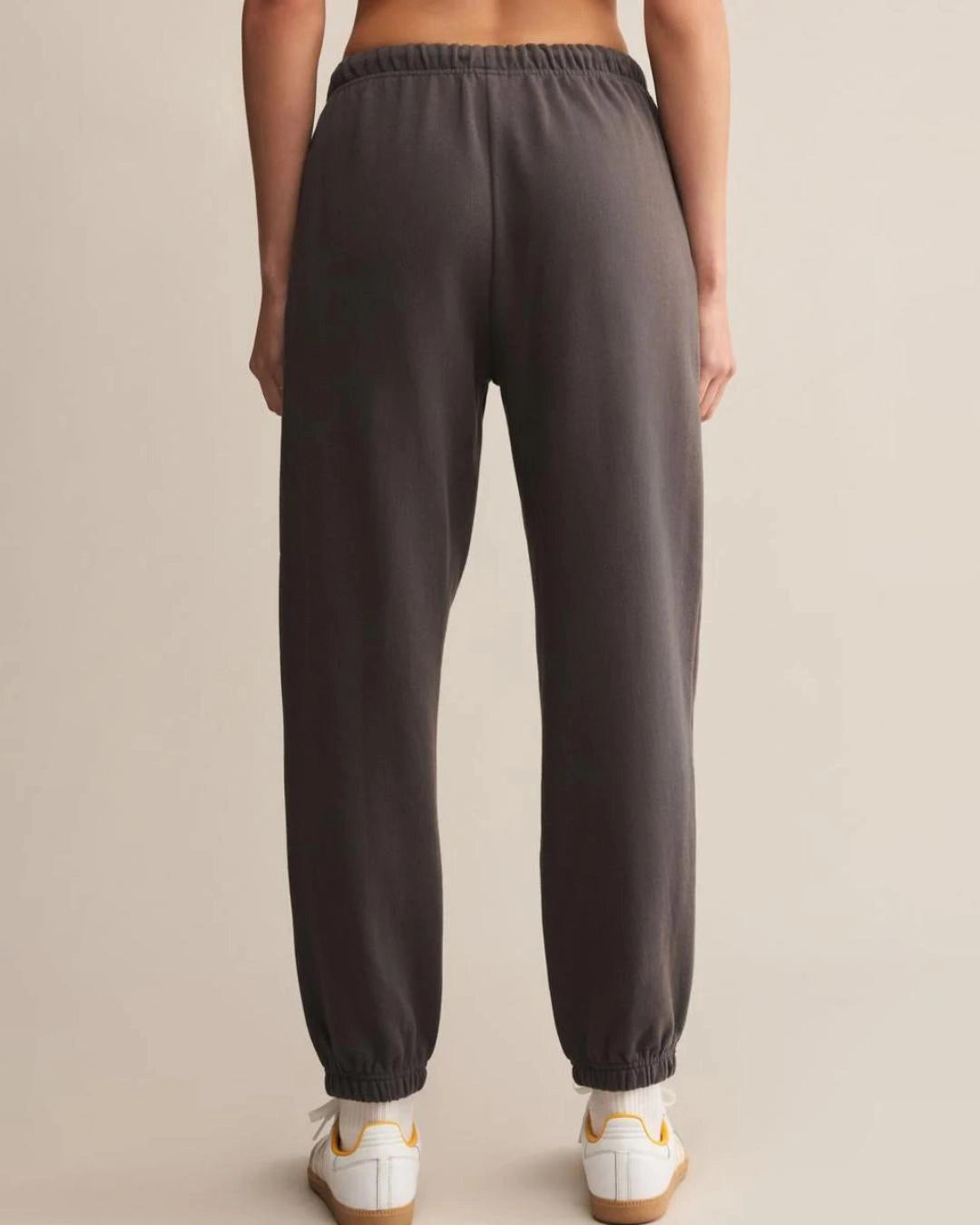 a woman wears dark gray cotton sweatpants with cream drawstring