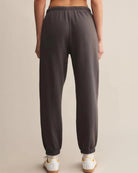 a woman wears dark gray cotton sweatpants with cream drawstring