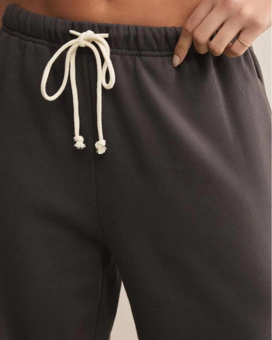 a woman wears dark gray cotton sweatpants with cream drawstring