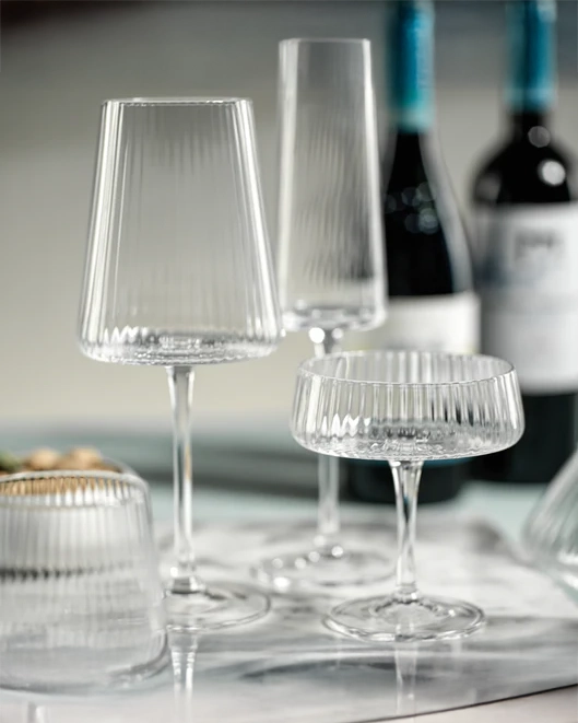 A clear fluted textured wine glass with a solid base, designed for drinking wine.