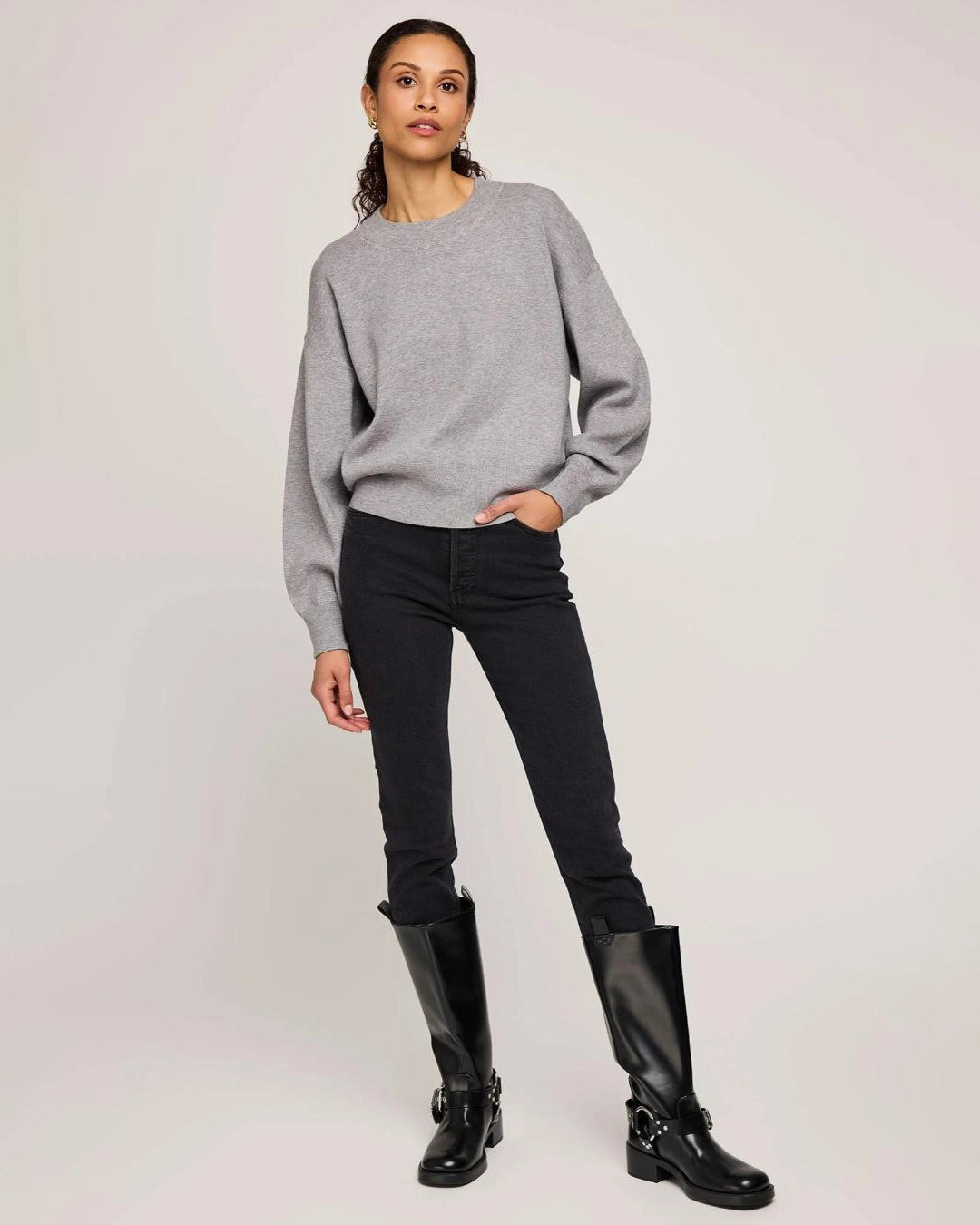 Woman wearing a gray crew neck sweater