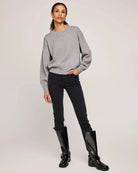 Woman wearing a gray crew neck sweater