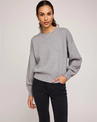 Woman wearing a gray crew neck sweater